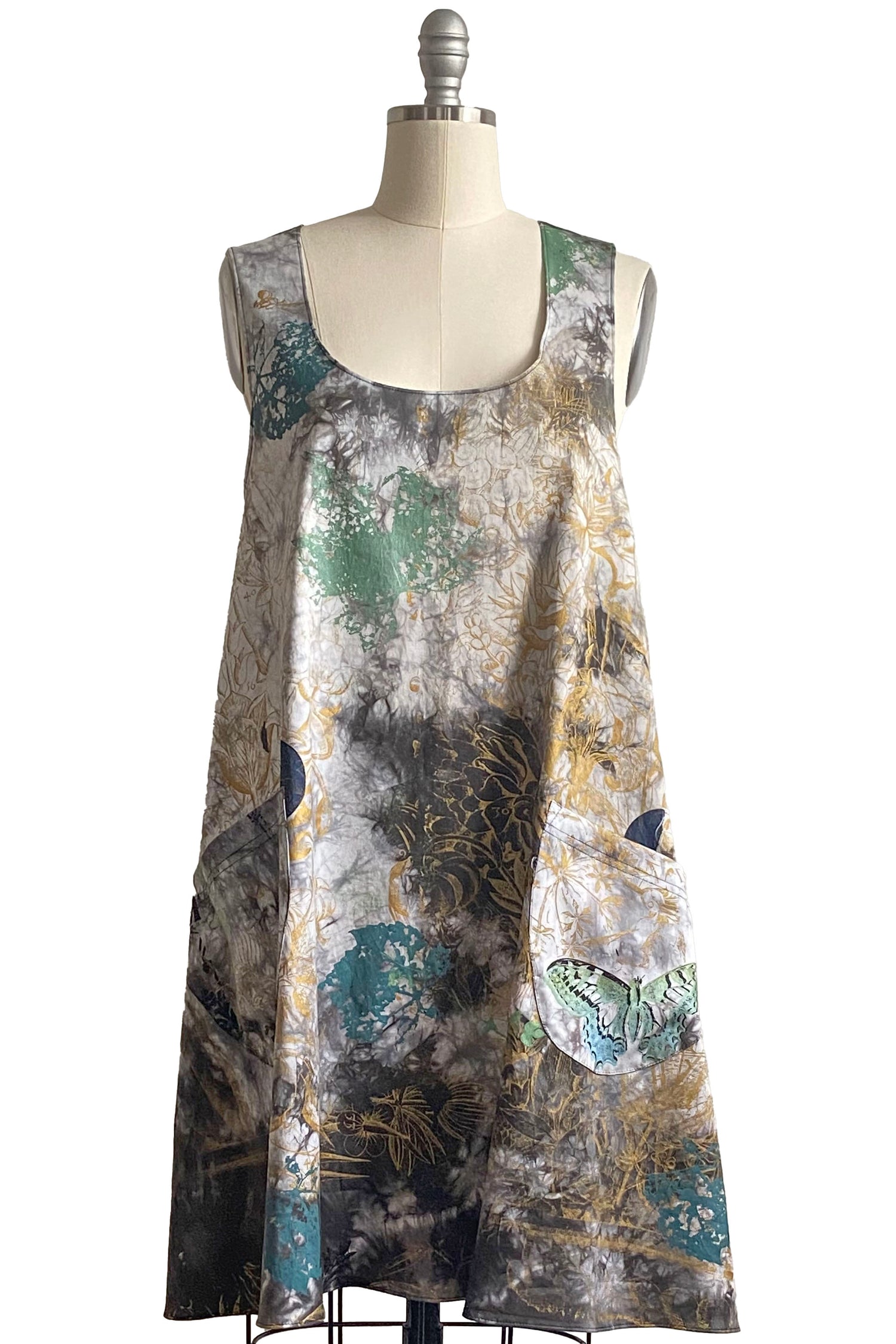 Handcrafted apron dress with crisscross back, functional front pockets, practical silhouette, and an adjustable open design for comfort and movement.